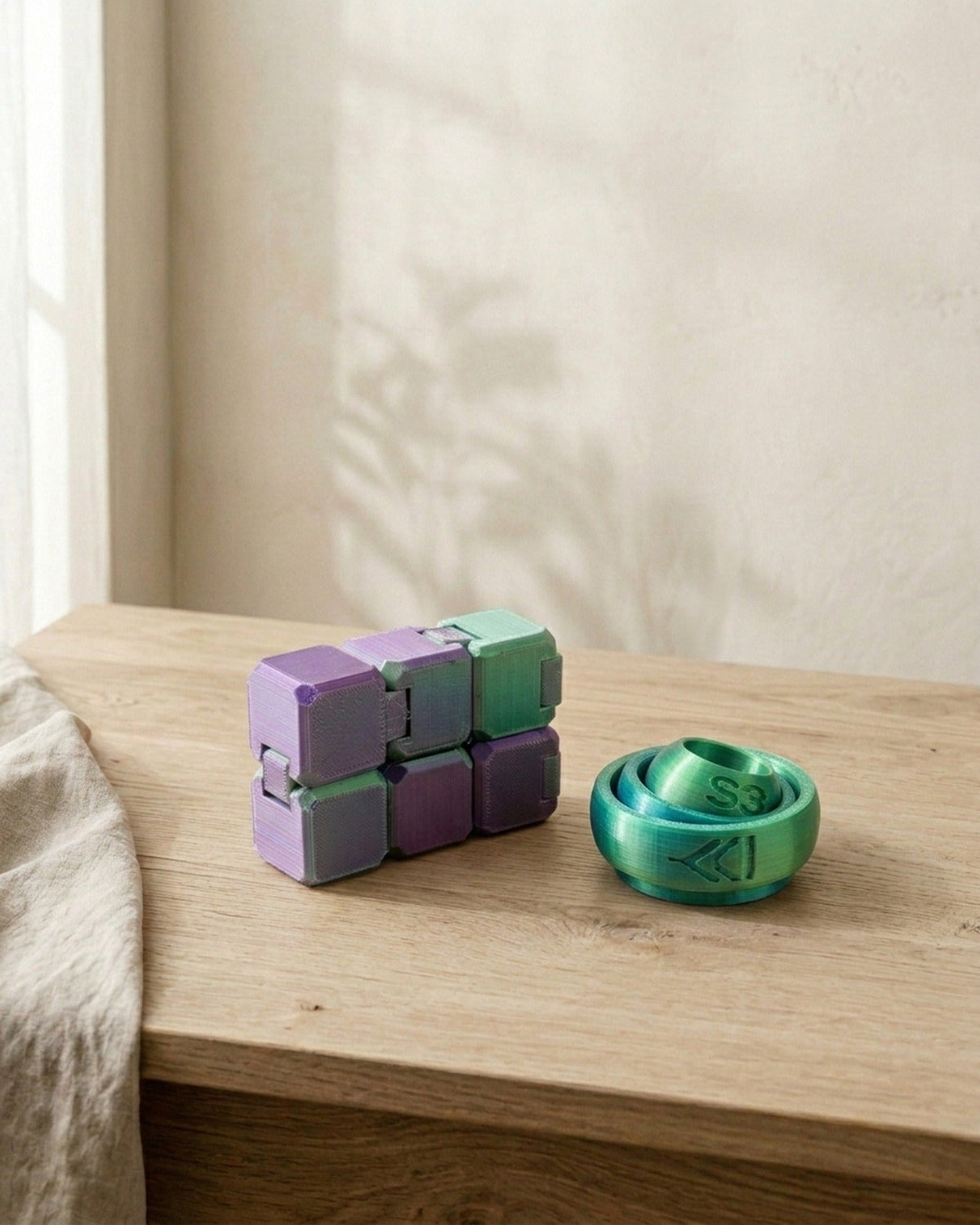 Two 3D-printed PLA fidgets: an infinity cube and a ring fidget