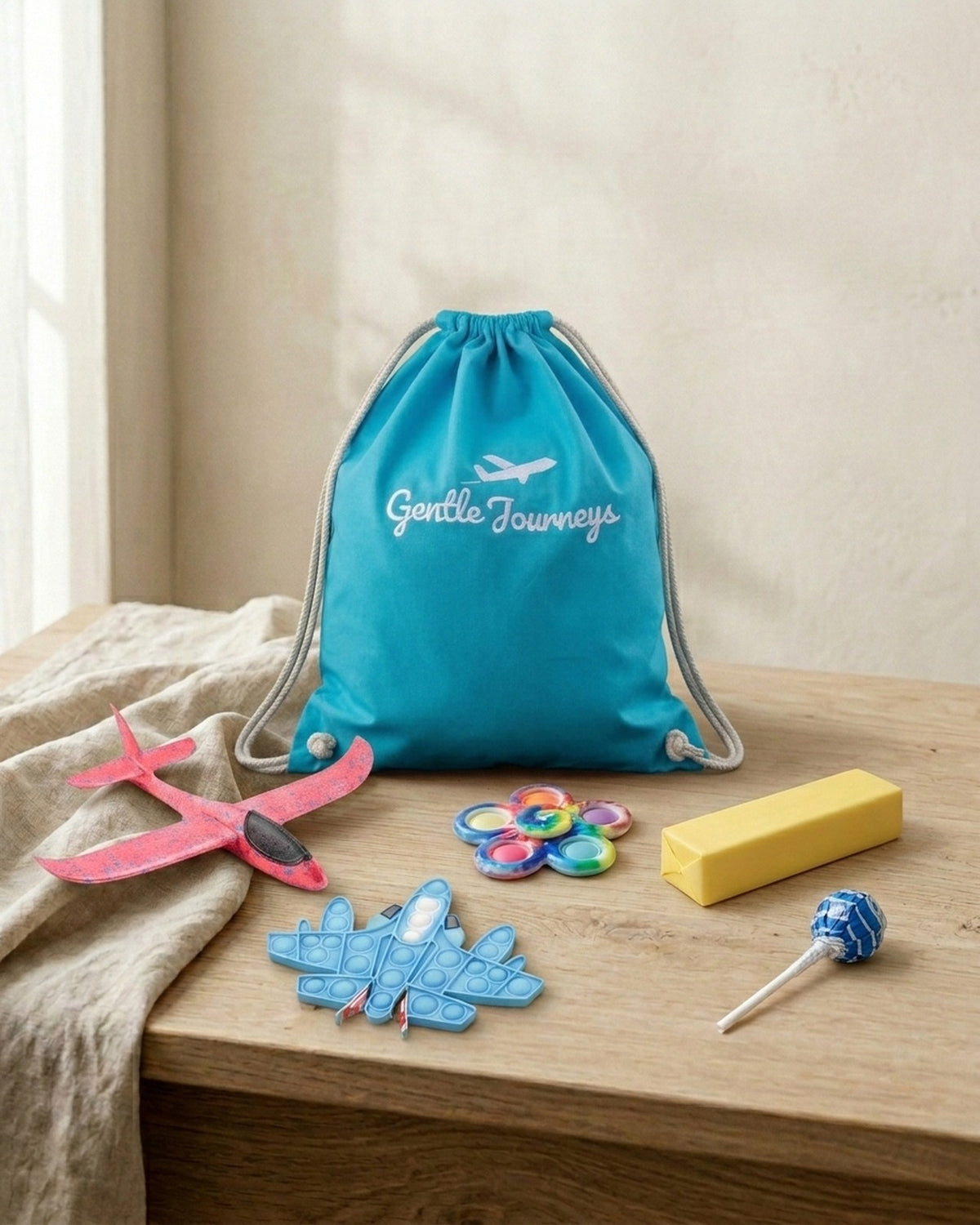 Blue Soft Cotton sensory travel bag with the foam glider, aeroplane pop it, tie-dye spinner, butter squishy and sugar-free lollipop