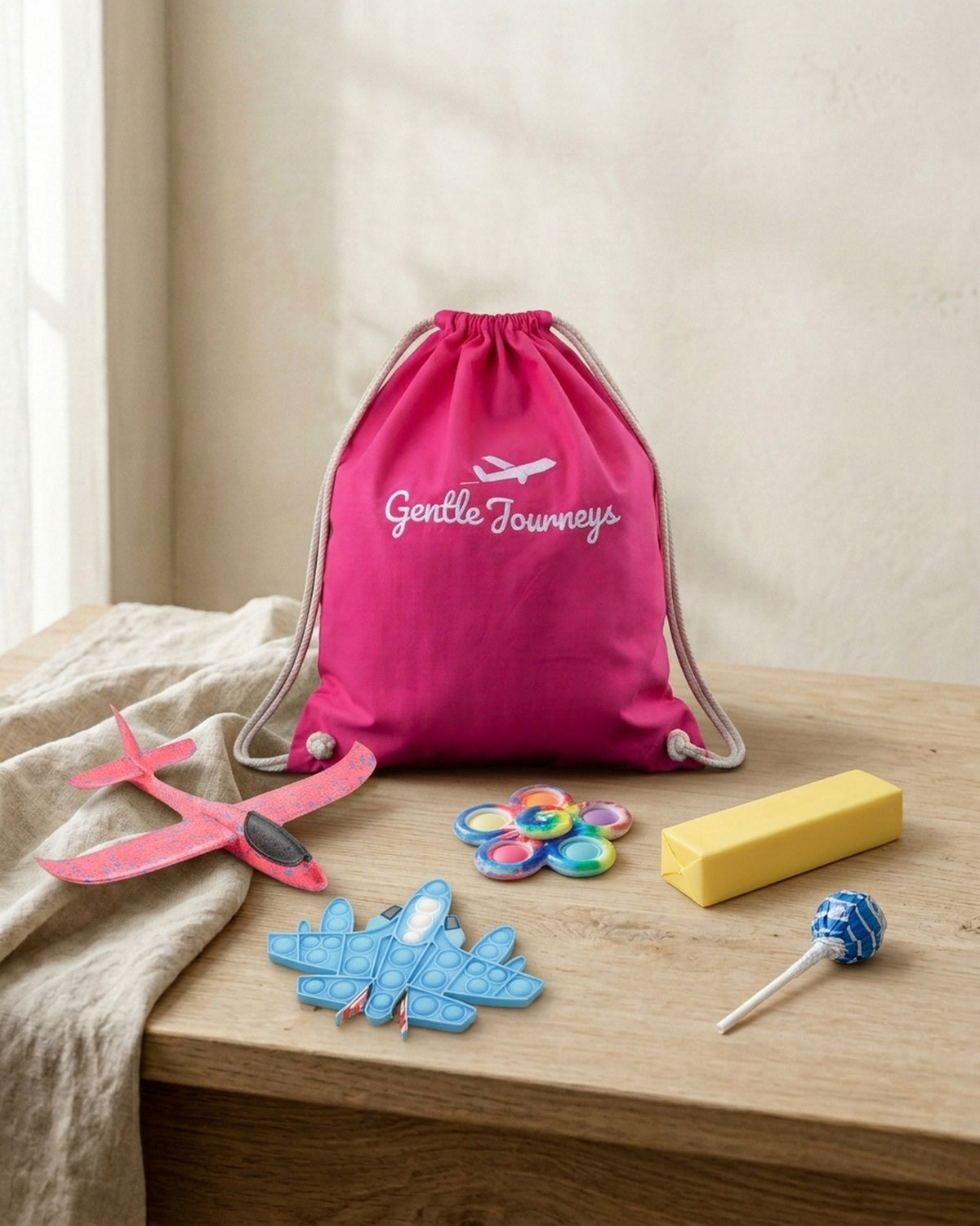 Pink Soft Cotton sensory travel bag with the foam glider, aeroplane pop it, tie-dye spinner, butter squishy and sugar-free lollipop
