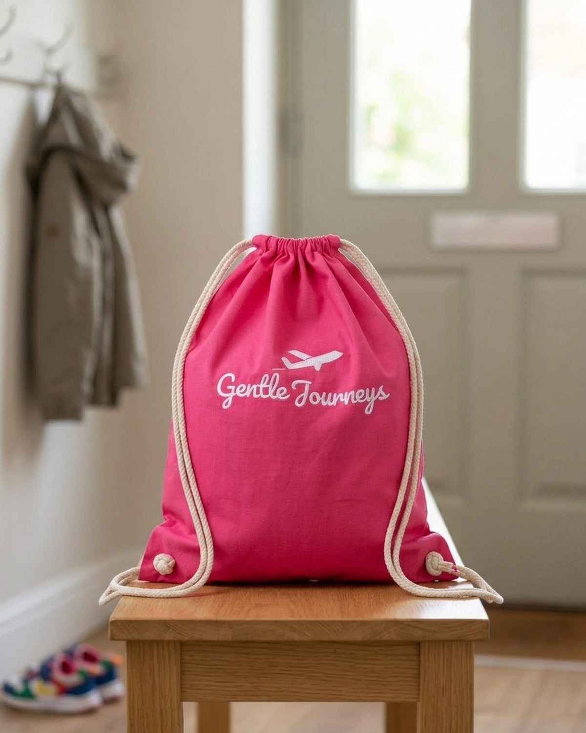 Pink Soft Cotton sensory travel bag on a hallway bench by the front door