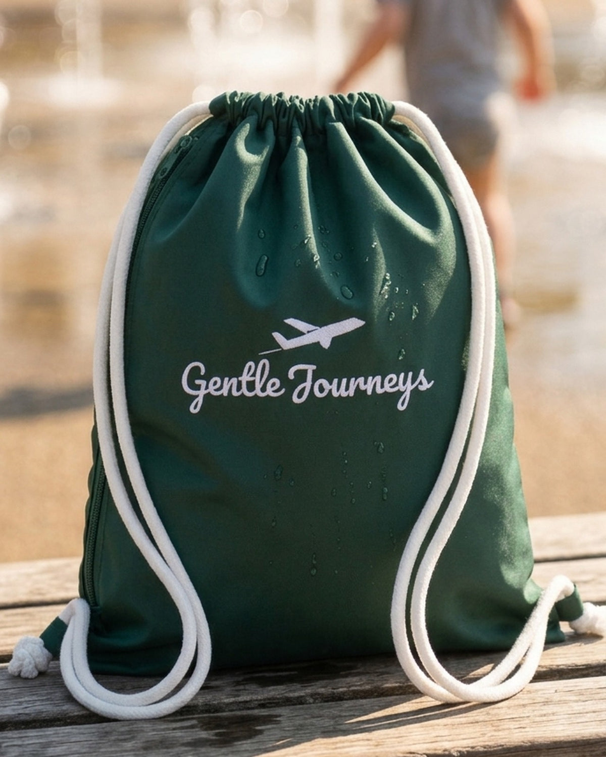 Green Water-Resistant sensory travel bag on a bench by a splash park