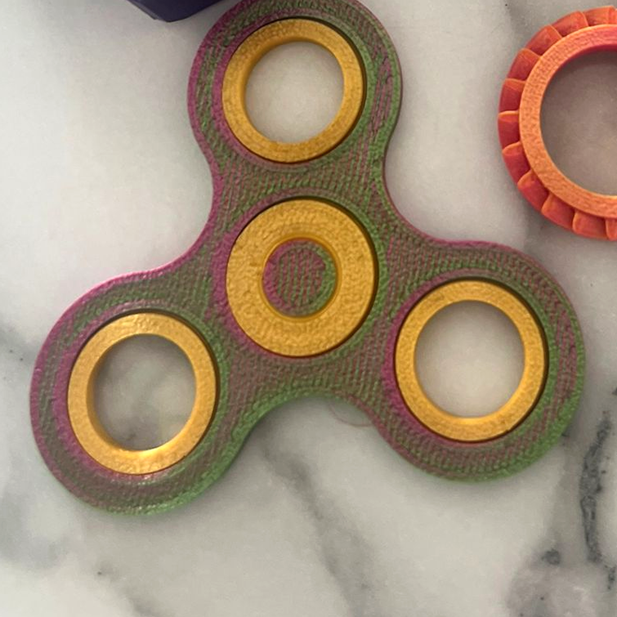 Gentle Journeys fidget spinner in pearlescent gold, green and pink PLA