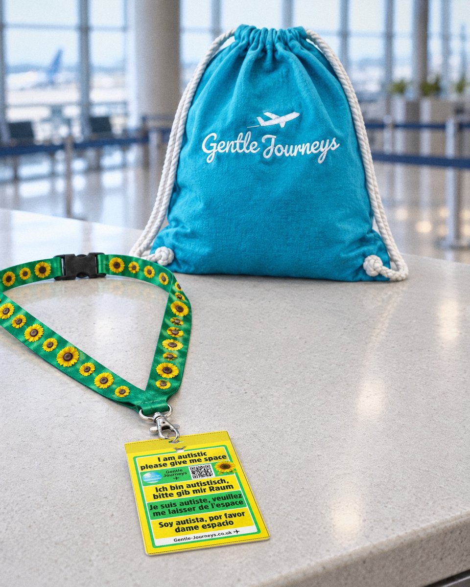 Turquoise Gentle Journeys bag on an airport check-in desk, the Sunflower lanyard and 4-language card in front